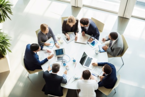 Gruppe von Menschen um einen runden Tisch